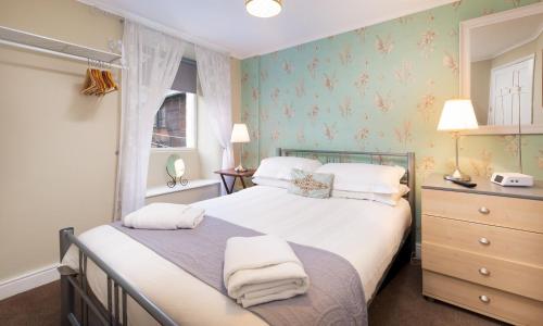 a bedroom with a bed with towels on it at Ghyll Foot Cottage in Ambleside