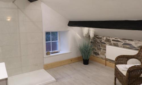 a living room with a chair and a window at Ghyll Foot Cottage in Ambleside