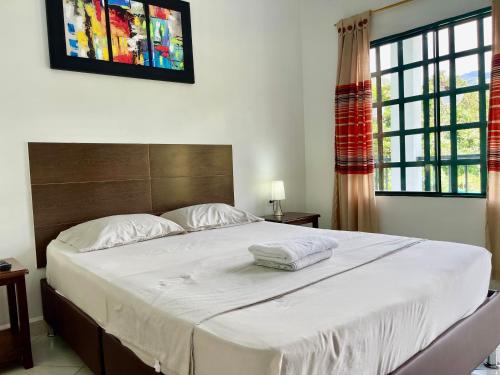 a bedroom with a large bed with white sheets at Quinta Baroe in Guaduas