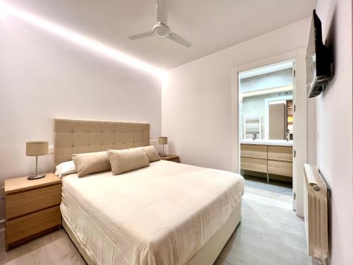 Housingleón - Palacio de Don Ramiro في ليون: غرفة نوم بيضاء بها سرير ونافذة