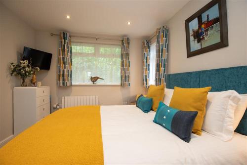 a bedroom with a large bed with yellow and blue pillows at Silver Howe in Grasmere