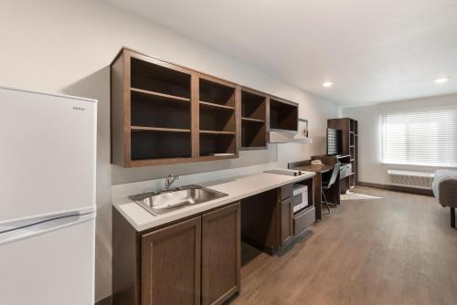 a kitchen with a sink and wooden cabinets at WoodSpring Suites Dayton North in Dayton