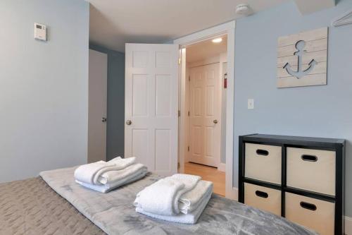 1 dormitorio con 2 toallas encima de la cama en 2BR Apt w/ 3 min Walk to downtown SWH - [Low Tide] en Southwest Harbor