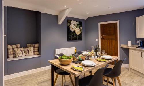a dining room with a wooden table with chairs at Riverville in Grasmere