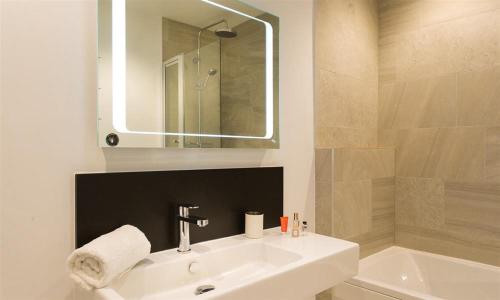 a bathroom with a sink and a mirror and a tub at Riverville in Grasmere