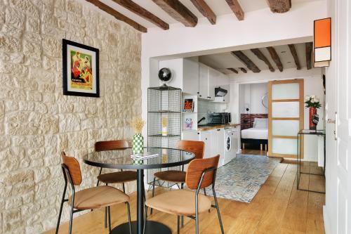 a kitchen and dining room with a table and chairs at Edgar Suites Montorgueil - Caire in Paris