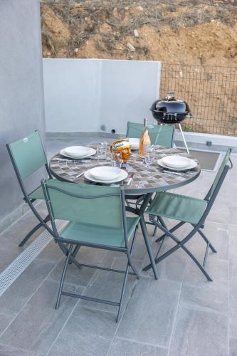 a table and chairs with plates and glasses on it at Villa L'Alba BASTIA by Location-tourisme-corse in Bastia