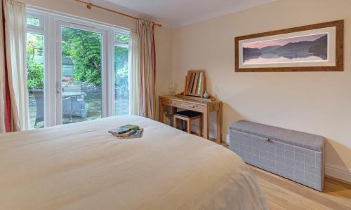 a bedroom with a large bed and a window at Wheatlands Cottage in Windermere