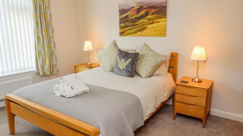 um quarto com uma cama com duas mesas de cabeceira e dois candeeiros em Bowderstone em Keswick