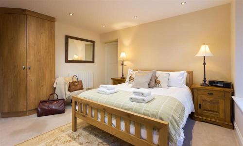 a bedroom with a large bed with towels on it at Deer Wood at Applethwaite Hall in Windermere