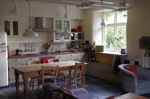 uma cozinha com uma mesa e algumas cadeiras e uma mesa e uma mesa; em Thomas Cottage em Penrith