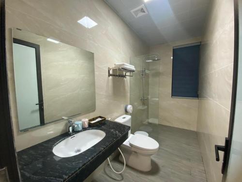 bagno con lavandino, servizi igienici e specchio di Minh Hưng Motel a Ha Long