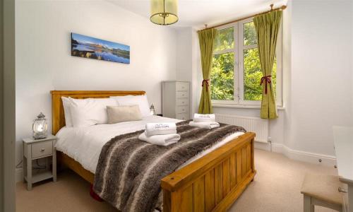 a bedroom with a bed with two towels on it at Ellerthwaite House in Windermere