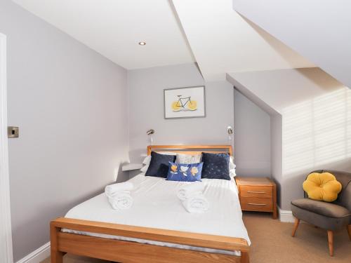 a bedroom with a bed and a chair at Lakestone Cottage in Windermere