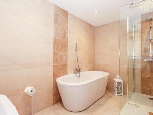 ein Badezimmer mit Badewanne und Glasdusche in der Unterkunft Lakestone Cottage in Windermere