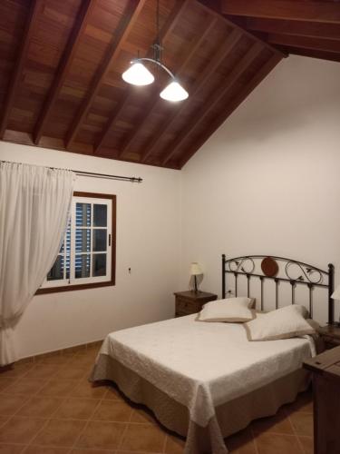a bedroom with a bed and a window at Casa con puesta de sol y montañas. in Cubaba