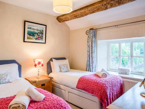 1 dormitorio con 2 camas y ventana en Knotts Cottage, en Windermere