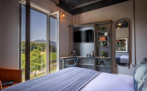 1 dormitorio con cama y ventana grande en Hotel67, en Killarney