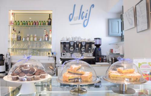 un comptoir avec trois plateaux de gâteaux et de pâtisseries dans l'établissement Corte Trullo Sovrano B&B, à Alberobello