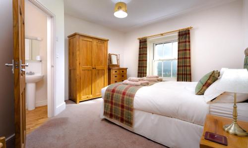 a bedroom with a bed and a sink and a window at Low Longthwaite Farm in Watermillock