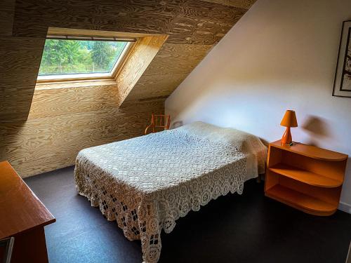 um quarto com uma cama e uma janela em Lisons des Sources em Nans-sous-Sainte-Anne