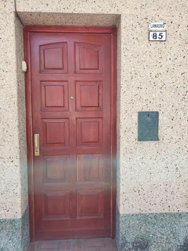 una puerta roja en el lateral de un edificio en Alvarado Apart en Salta