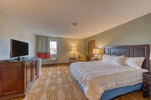 a hotel room with a bed and a flat screen tv at American Inn & suites in Dundee