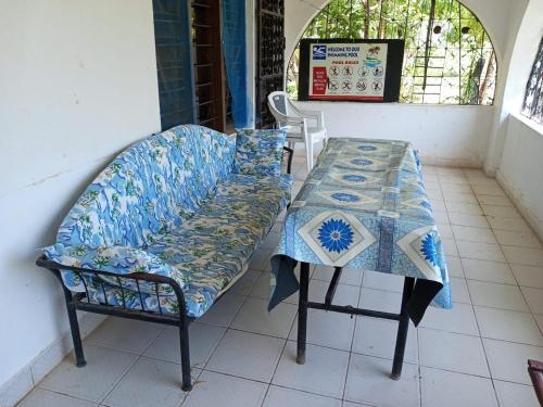 a table and a bench with blue and white at Fred Hunter Villa in Tiwi