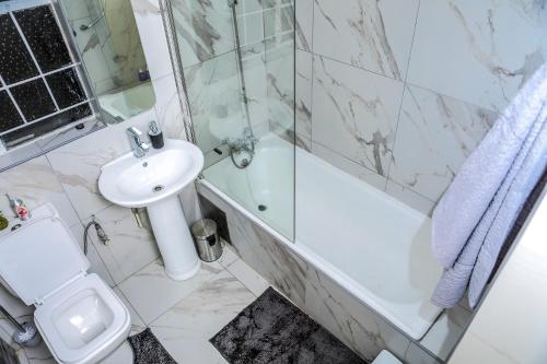 a bathroom with a sink and a shower and a toilet at Delux Guesthouse in Volksrust