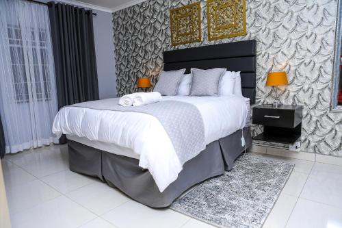 a bedroom with a large bed with two towels on it at Delux Guesthouse in Volksrust