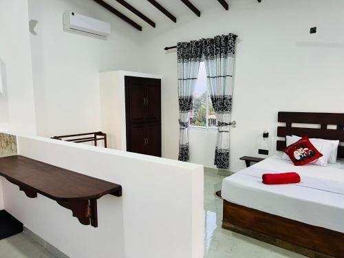 a bedroom with a bed and a desk in it at Indika's Apartment in Hikkaduwa
