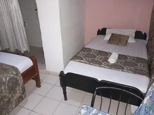 a small bedroom with a bed and a bedskirts at Fred Hunter Villa in Tiwi