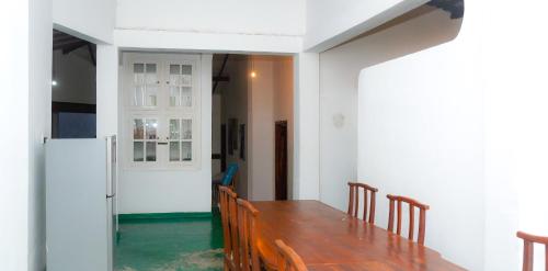 a dining room with a wooden table and chairs at V6 Holiday Bungalow in Badulla