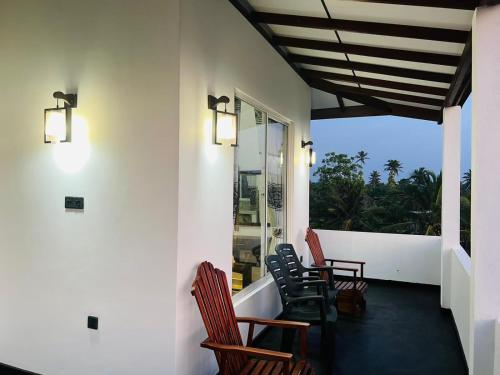 a balcony with chairs and a view of the ocean at Indika's Apartment in Hikkaduwa