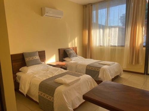 um quarto de hotel com duas camas e uma janela em Villa Garita Inn em La Garita