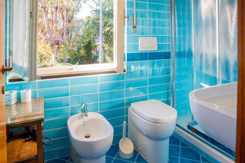 een blauw betegelde badkamer met een toilet en een wastafel bij 082 - Cà Marilù, 5 minuti da mare e centro di Sestri Levante in Sestri Levante