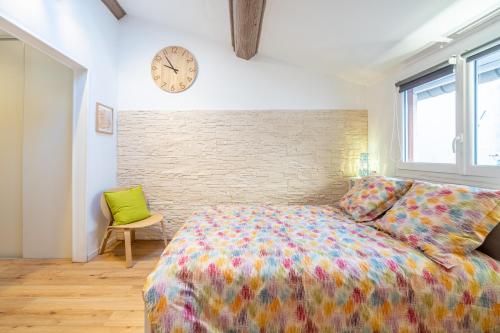 1 dormitorio con 1 cama y reloj en la pared en 'Les Arsenaux' Studio de charme coeur de Marseille by Weekome en Marsella