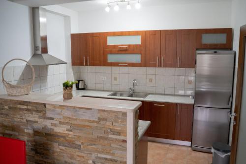 a kitchen with wooden cabinets and a stainless steel refrigerator at Apartman City Center AN Trebinje in Trebinje