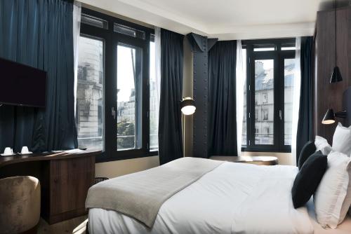 a bedroom with a large bed and windows at CasaÔ in Paris