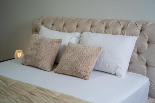 a group of pillows on a bed with a white headboard at Apartman City Center AN Trebinje in Trebinje