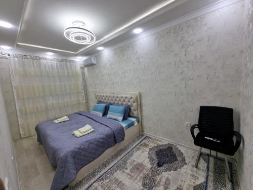 a bedroom with a bed and a chair in it at APARTMENT “NOVZA” in Tashkent