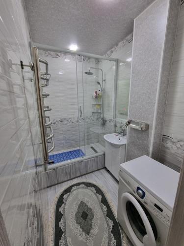a bathroom with a shower and a washing machine at APARTMENT “NOVZA” in Tashkent