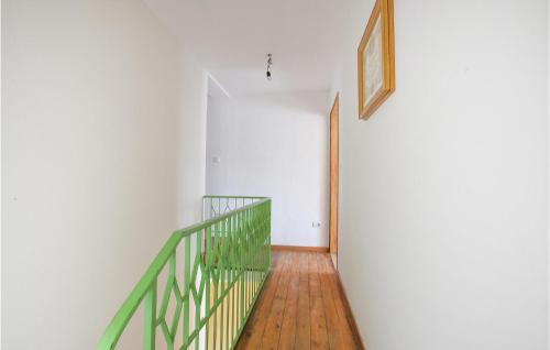 a hallway with a green railing and a stair case at Awesome Home In Aune Di Sovramonte in Sovramonte