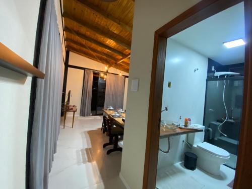 a bathroom with a sink and a toilet and a desk at Vila Uluwatu 1 in Florianópolis