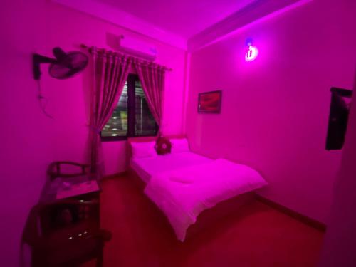 a pink room with a bed and a window at Nhà Nghỉ Hương Trà 2 Tân Phú 