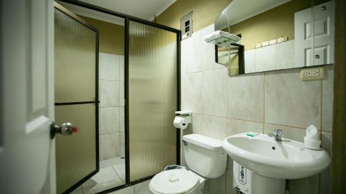 uma casa de banho com um chuveiro, um WC e um lavatório. em Coati Arenal Lodge em La Fortuna