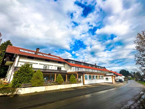 a building with a red roof on a street at Hotel Bergstätter Hof in Immenstadt im Allgäu