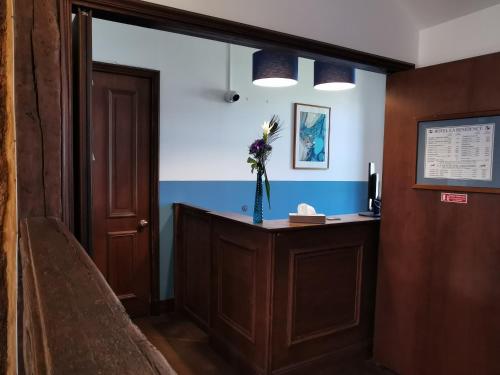 a hallway with a door and a flower in a vase at Hotel La Résidence Manoir De La Salamandre in Étretat