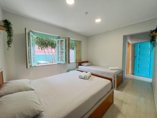 a bedroom with two beds and a window at Kali Vice Surf Villa in Costa da Caparica