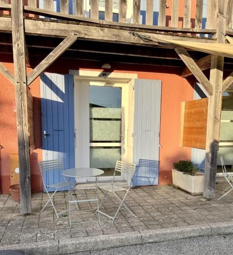 a table and chairs sitting outside of a building at Hôtel Rose des Vents in Baix